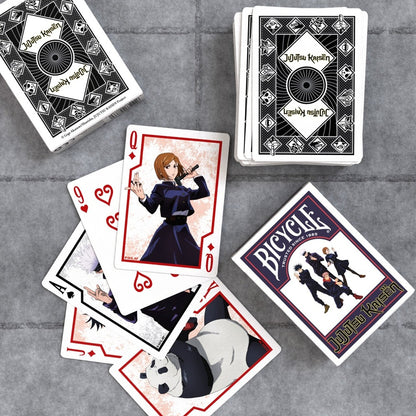 Bicycle playing cards featuring Jujutsu Kaisen characters scattered on a table, including Nobara, Gojo, and Panda