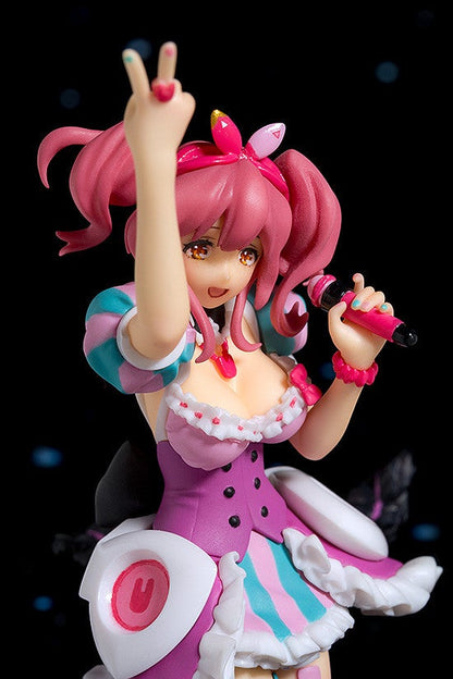 Pink-haired anime figurine with victory hand sign wearing a purple dress and microphone