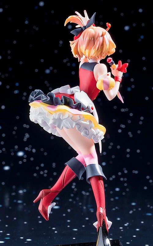Anime figurine of a girl in red and white outfit with a tiered skirt singing into a microphone