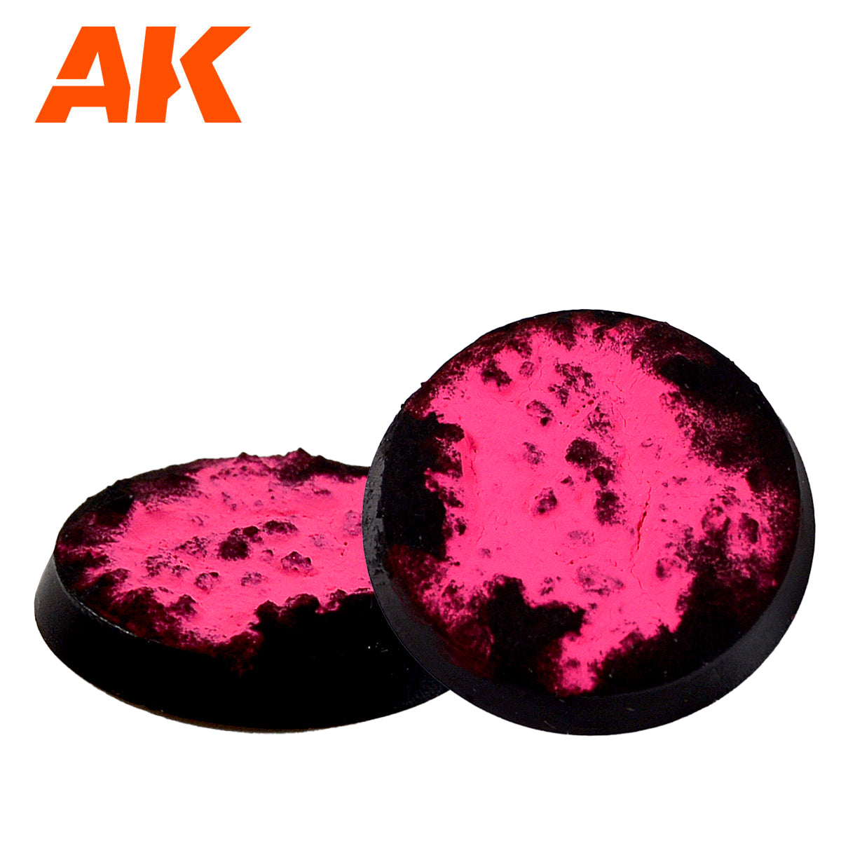 Two black circular miniature bases by AK with vibrant pink and dark, textured terrain