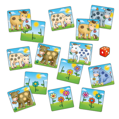 Colorful cartoon cow and flower matching game tiles scattered with a red die