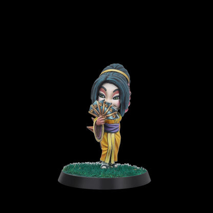 Painted chibi miniature: character in yellow kimono holding a blue fan to its face, green eyes peeking over, on a grassy base.