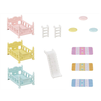 Miniature baby furniture set: three pastel cribs, a slide, two ladders, and colourful patterned rugs