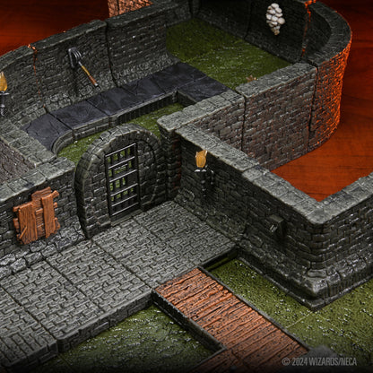 Overhead view of modular dungeon terrain with stone walls, a barred gate, moss, cobblestone, and a wooden bridge
