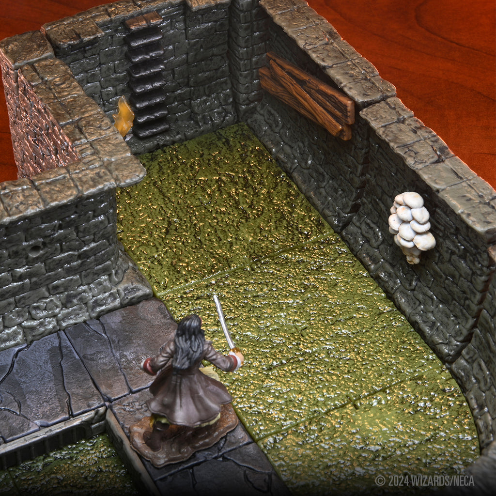 A miniature woman with long hair and a sword stands on a stone path looking into a dungeon room with a textured green floor and stone walls