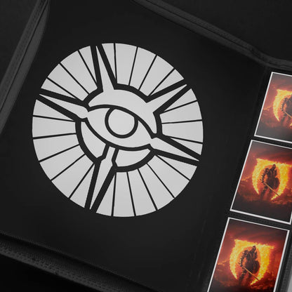 Black card binder with a large white radiant eye logo on the cover, holding three fantasy warrior trading cards
