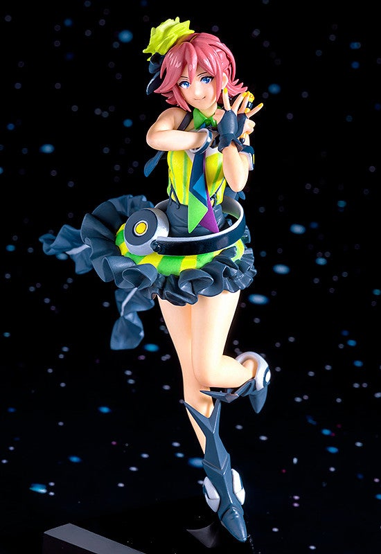 Anime figure of a girl with pink hair in a brightly colored outfit posing against a starry background