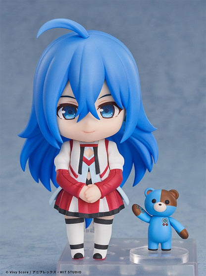 Blue-haired anime figure in white and red jacket and skirt standing next to a small blue and brown teddy bear