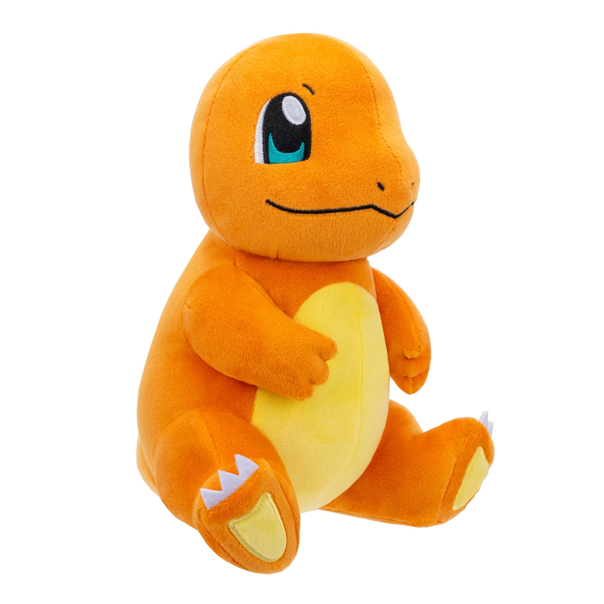 A cuddly, textured orange Charmander Pokémon plush sits facing right, displaying its bright yellow belly and detailed embroidered eyes on a white background
