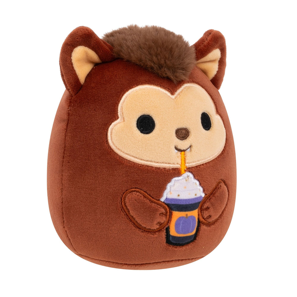 A brown monkey plush toy with fuzzy hair, holding a Halloween drink cup with whipped cream and a purple pumpkin design