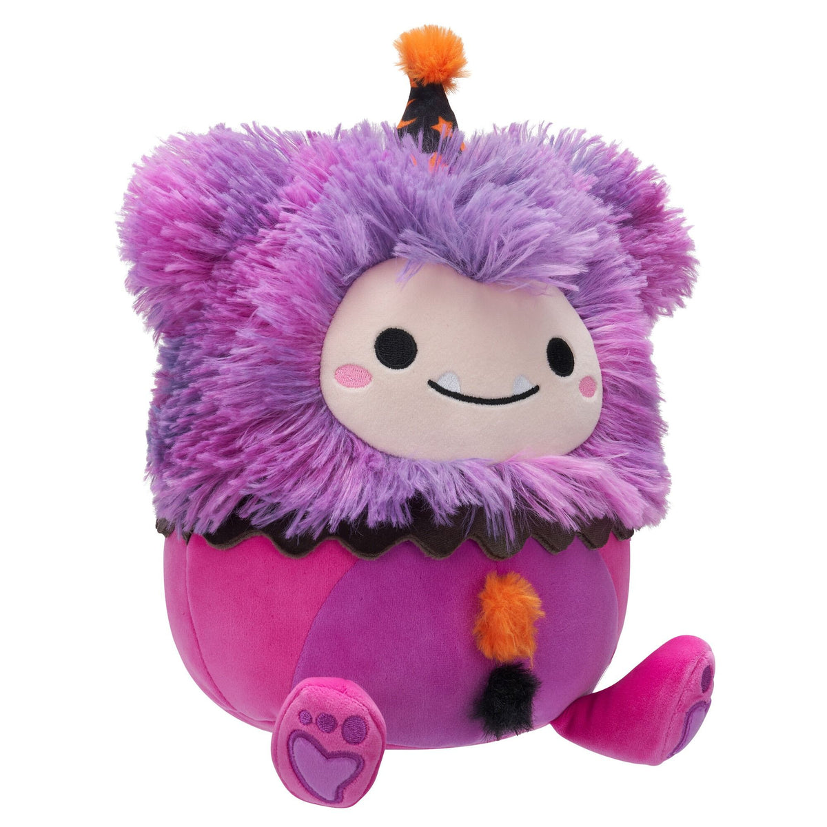 A fuzzy purple and pink monster plush toy sits, wearing a small black and orange party hat and a cute face with two tiny fangs