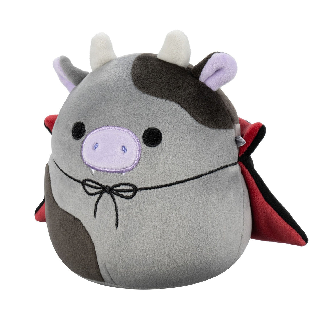 A plush grey cow with dark patches, white horns, purple snout and ears, fangs, and a red vampire cape with a black bow