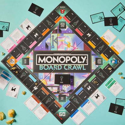 A Monopoly Board Crawl game board is laid out on a teal surface surrounded by title deed cards, chance cards, and gold game pieces