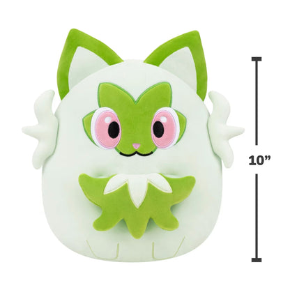 A 10 inch Squishmallows Sprigatito plush, showing the light green body, prominent green leaf mask, and embroidered pink eyes