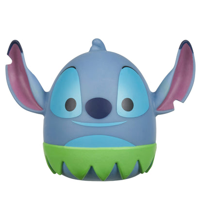 A Squooshems Disney Lilo & Stitch character, round and blue with large ears, blue eyes, a dark blue nose, a wide smile, and a green serrated skirt base