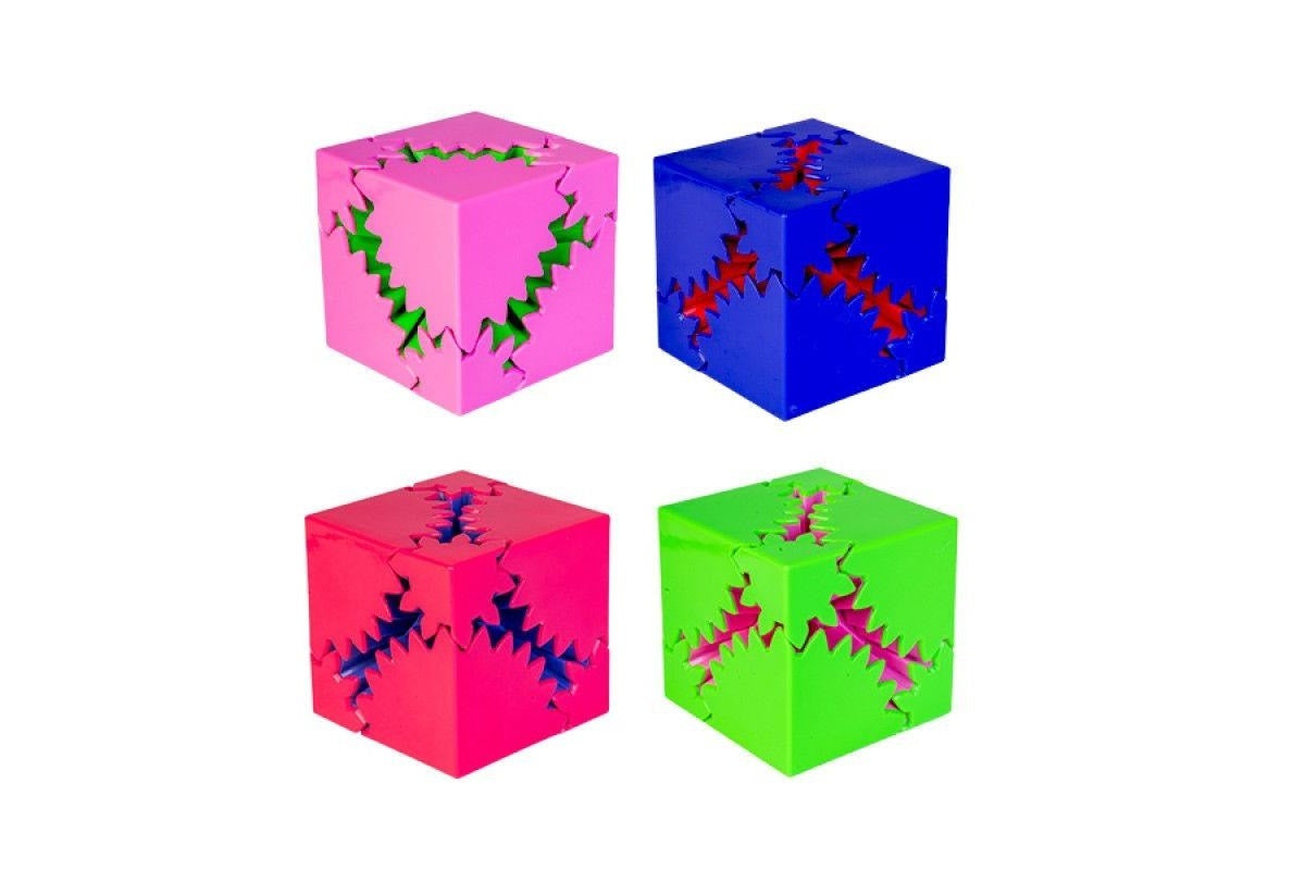 Set of four colorful interlocking gear cubes (pink, blue, red, green) on a white background