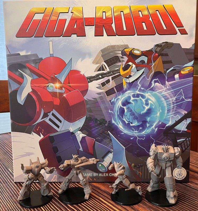 GIGA-ROBO! board game box art depicts two giant robots battling in a city and four unpainted robot miniatures stand in front