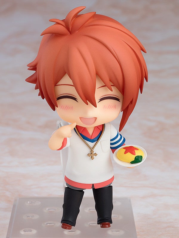 Nendoroid character with orange hair white shirt and black pants holding a small plate of food