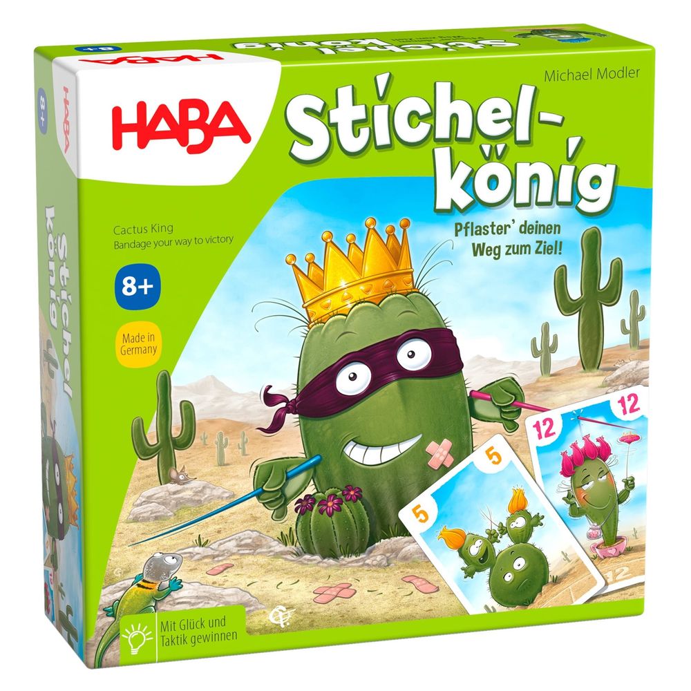 HABA Stichel-Konig game box. A grinning, crowned cactus in a mask, with a bandage, holds two sticks in a desert.