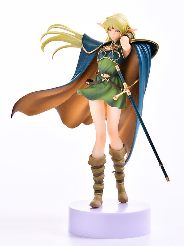 Anime figure of a female elf in a green dress blue and gold cape and brown boots holding a sword