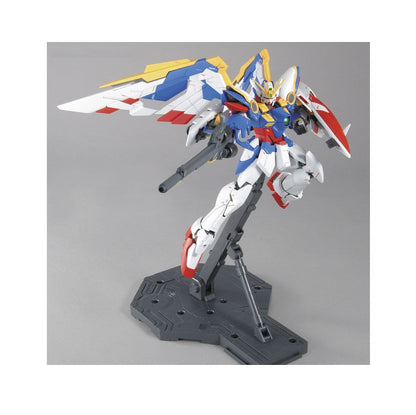 Detailed blue, white and red winged Gundam model holding a rifle, posed dynamically on a display stand