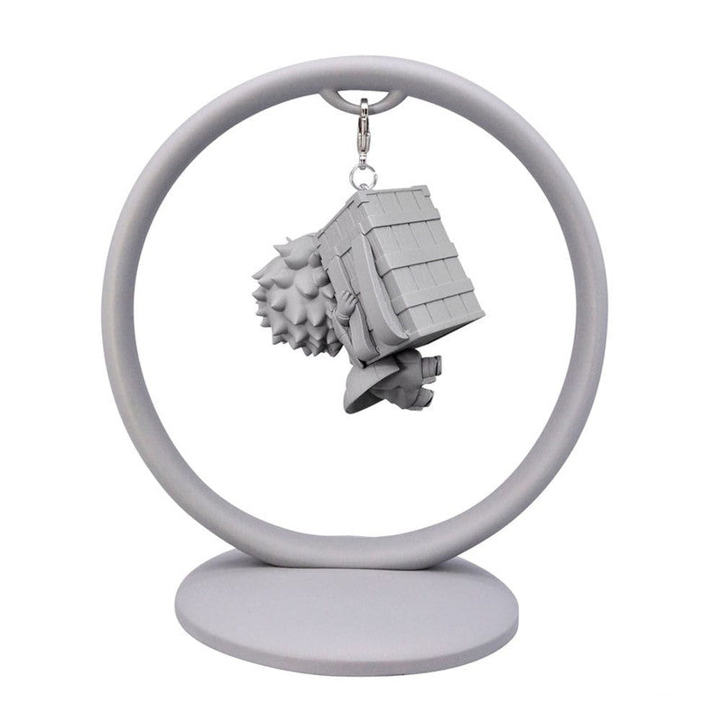 Grey figurine keychain with a house and character dangling from a circular stand
