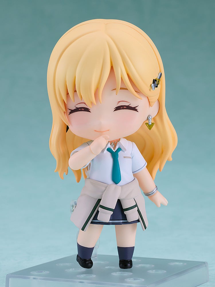 Blonde Nendoroid figure smiling with closed eyes, hand to chin, wearing a school uniform and sweater