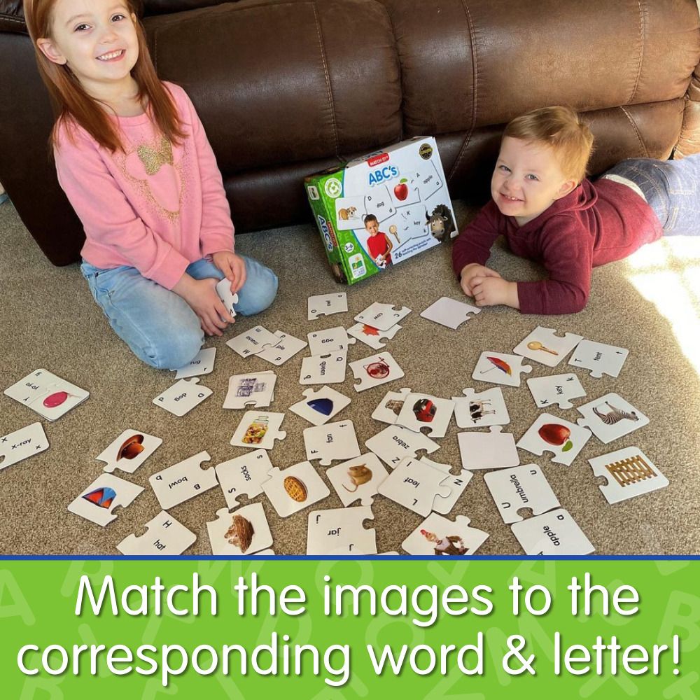 Two children playing an educational ABC puzzle matching game on the carpet