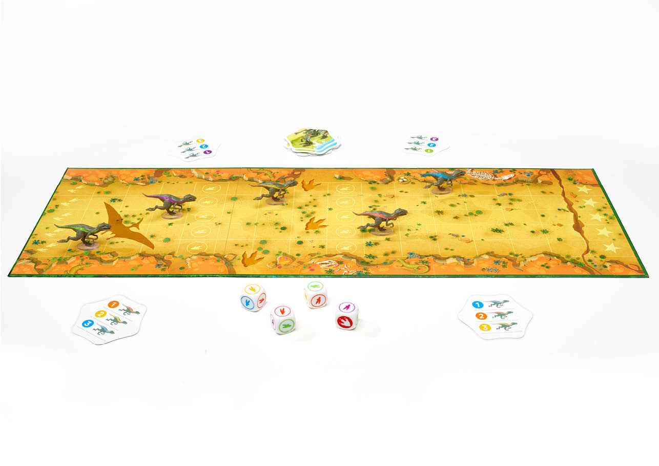 The Raptor Race board game set up with its desert-themed game board, colorful dinosaur miniatures, a pterodactyl, dice, and various game cards