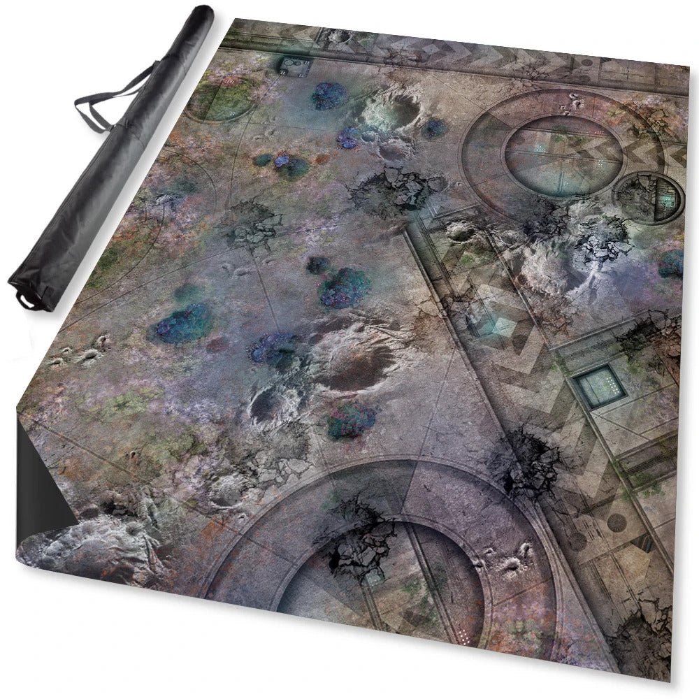 Overhead of a grey sci-fi gaming mat with craters, geometric patterns, and blue accents, beside its black case