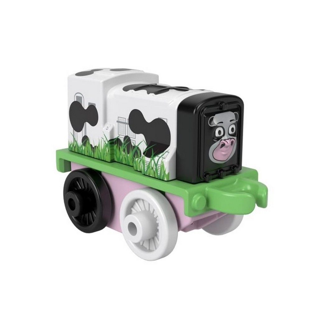 A mini toy train designed like a cow, featuring white with black spots, green trim, and a cartoon cow face on the front