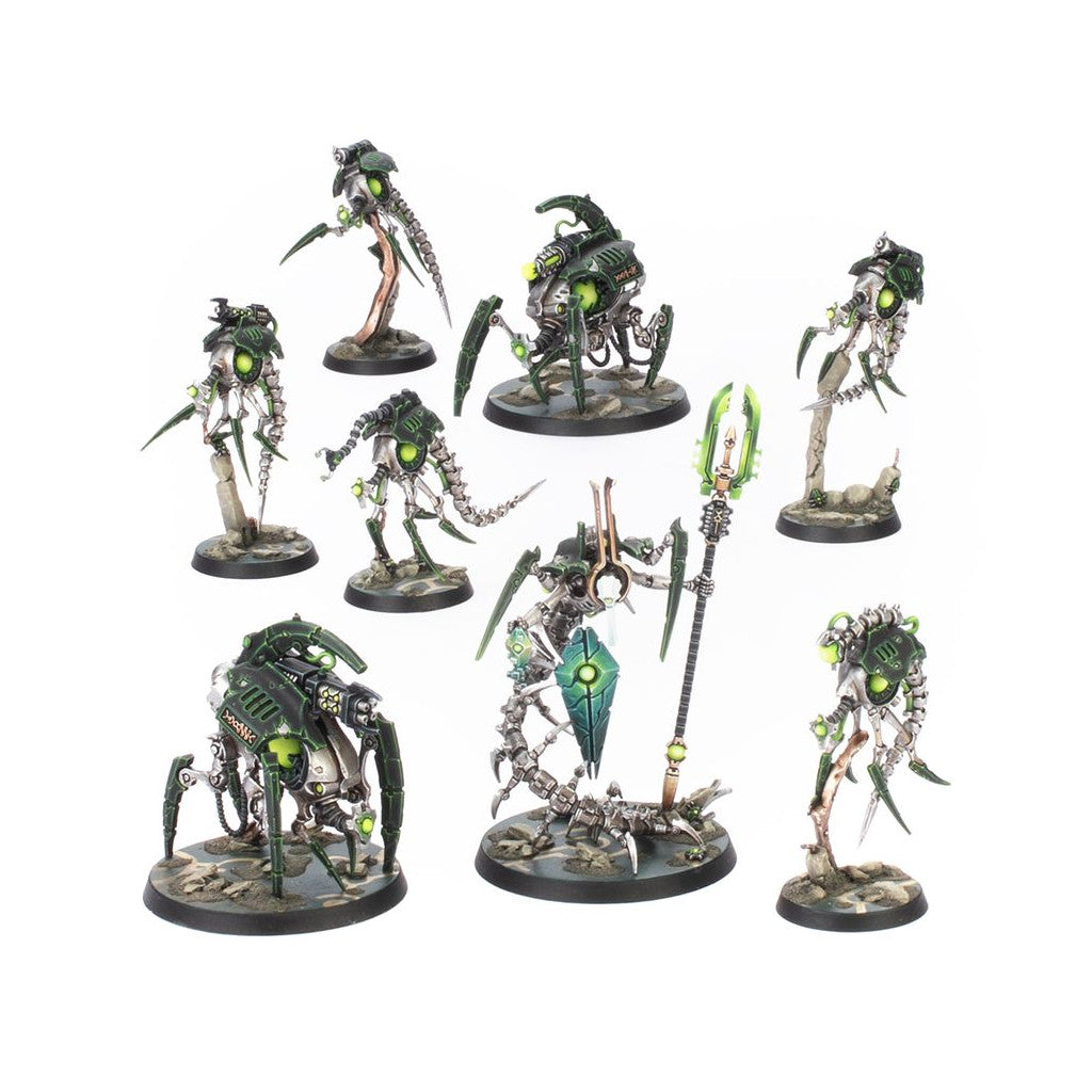 Set of seven Necron miniatures, silver and dark green robotic warriors with glowing green eyes and energy, including Skorpekh Destroyers and a Cryptek model