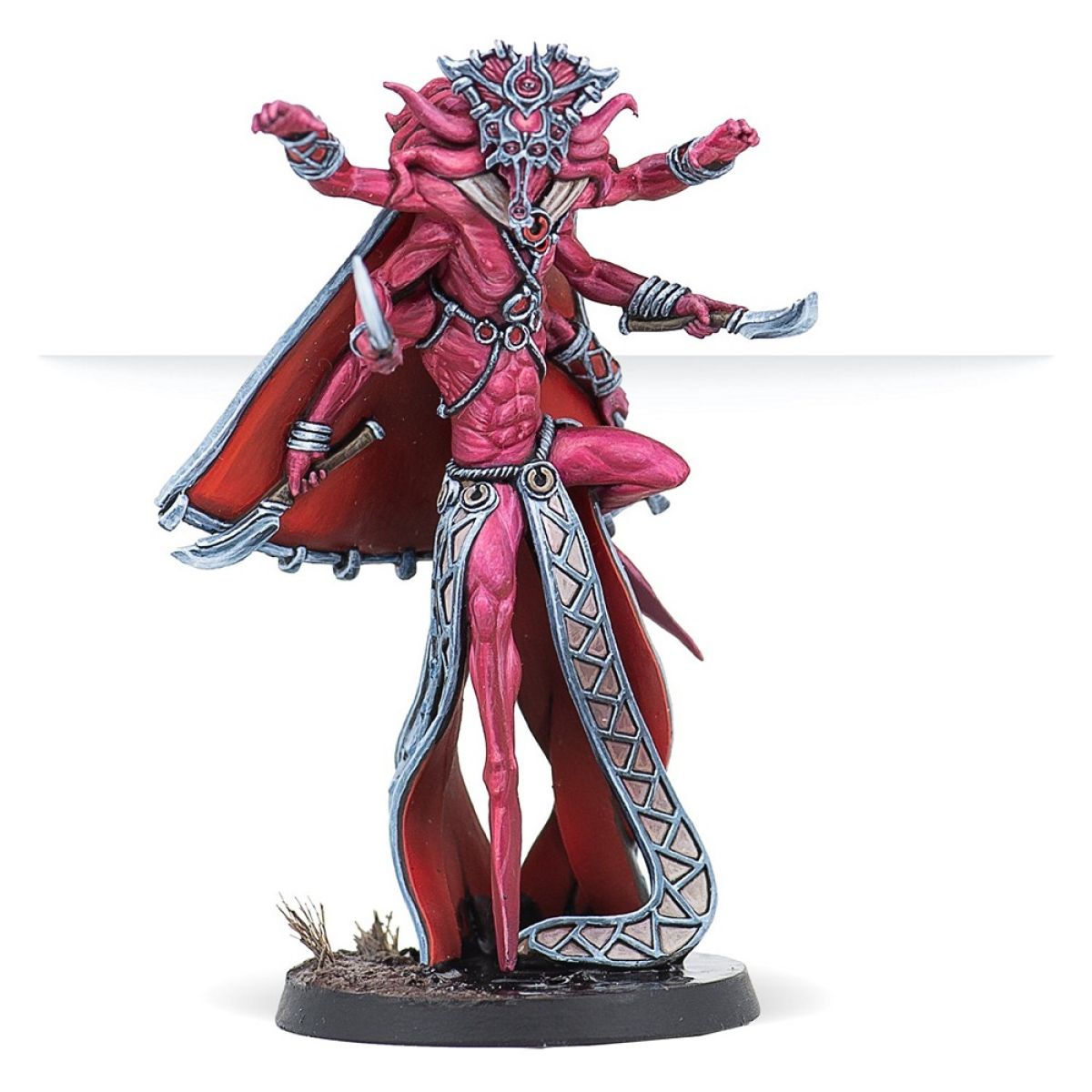 A miniature of a four-armed, slender red daemon wearing a cape and crown, posed holding two curved knives