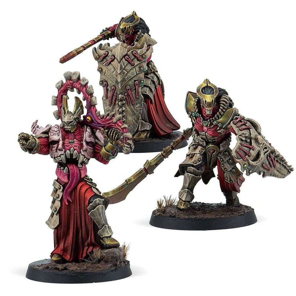 Three grotesque, bone-armored chaos miniatures in red, armed with shields and curved blades