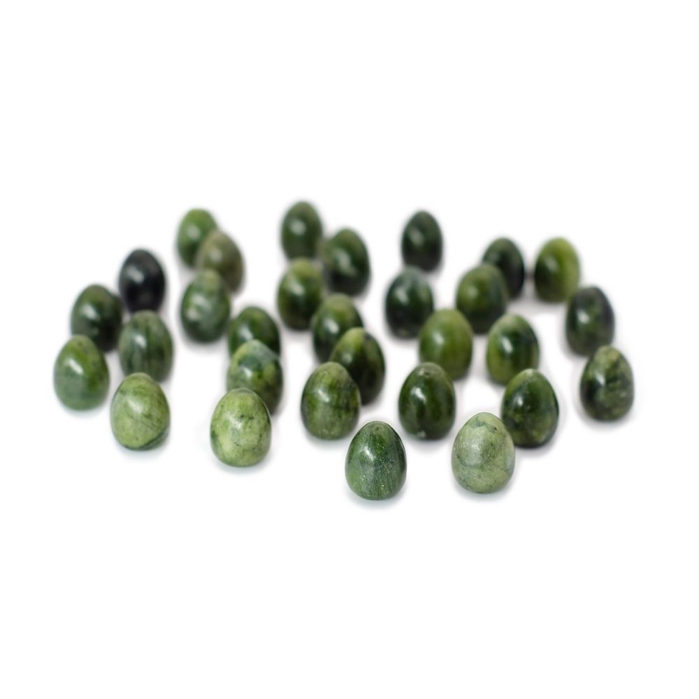 Scattered mottled green jade gemstone beads on a white background