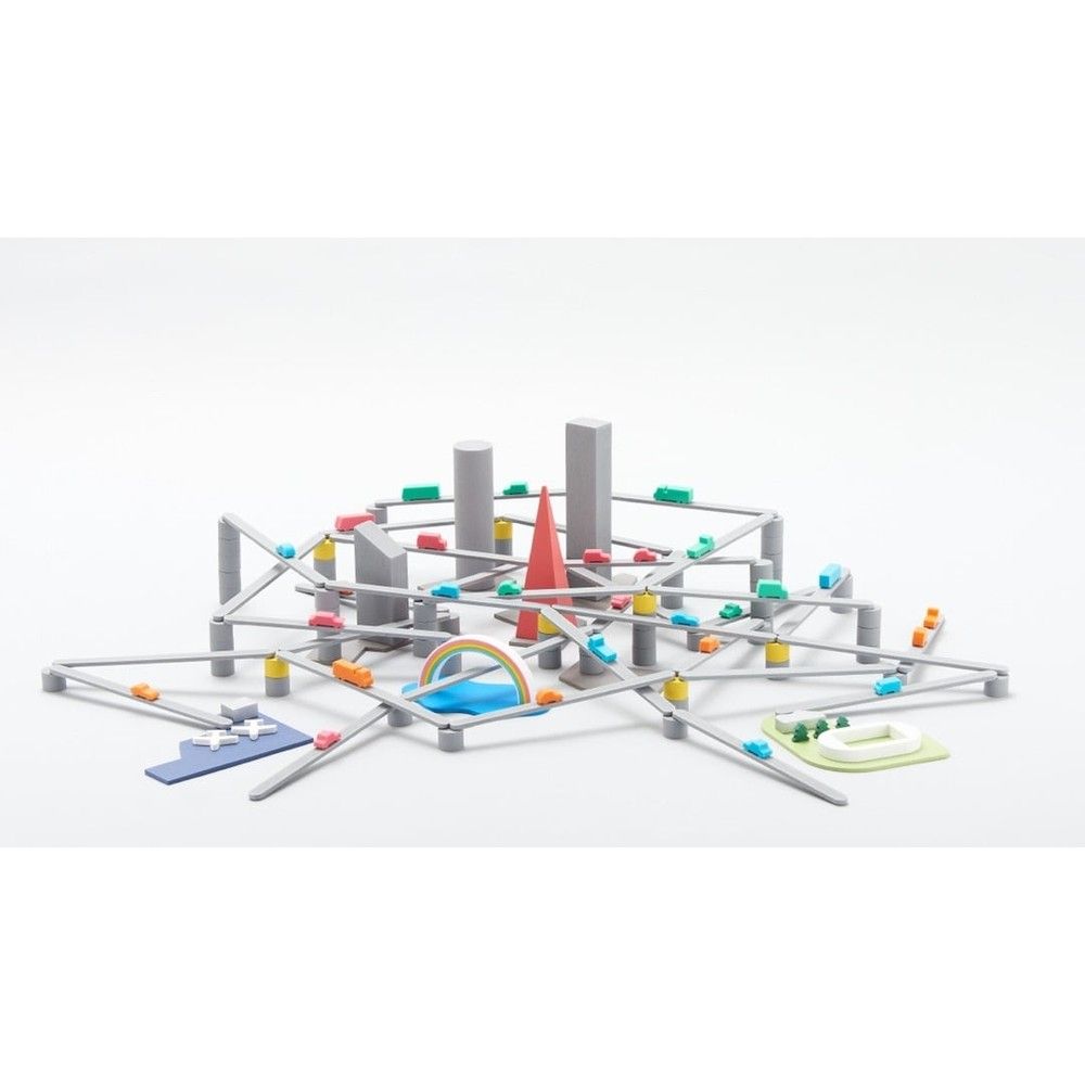 Elevated gray toy road network with small colorful cars, miniature buildings, and a red spire centerpiece