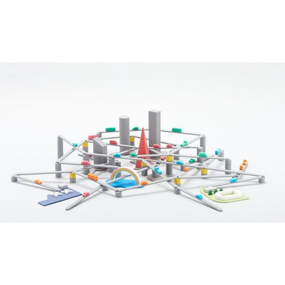 Elevated gray toy road network with small colorful cars, miniature buildings, and a red spire centerpiece