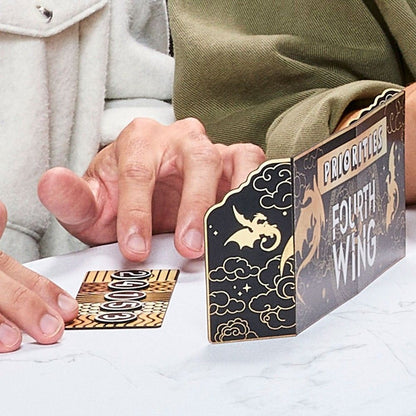 Hand moves game tokens next to a black and gold "Fourth Wing" priorities screen with dragon art
