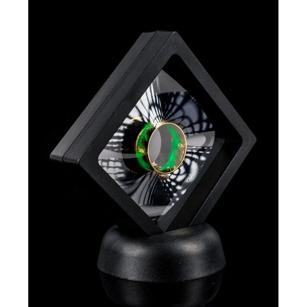 Gold ring with green pattern displayed in a black floating suspension case on a stand