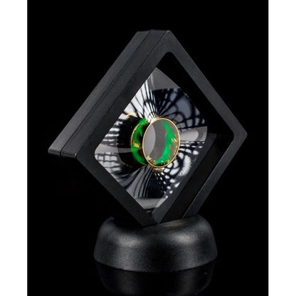 Gold ring with green pattern displayed in a black floating suspension case on a stand
