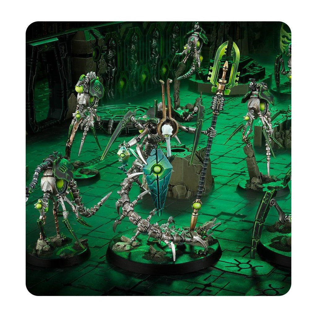 Necron Warhammer 40K miniatures: metallic robots with bright green glow, including a large central destroyer unit, posed on a glowing sci-fi battleground