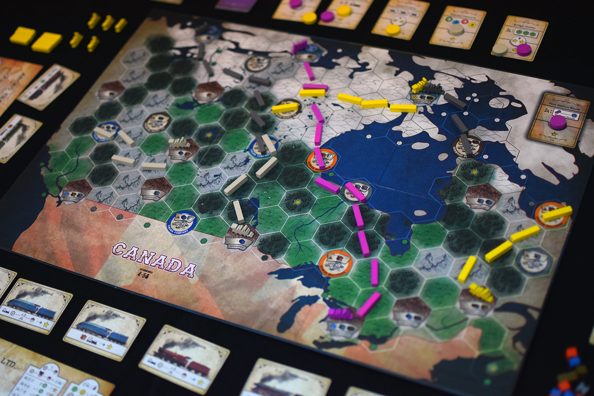 A railroad board game map of Canada and northern US, covered in hexagonal territories, colorful train routes, and city tokens