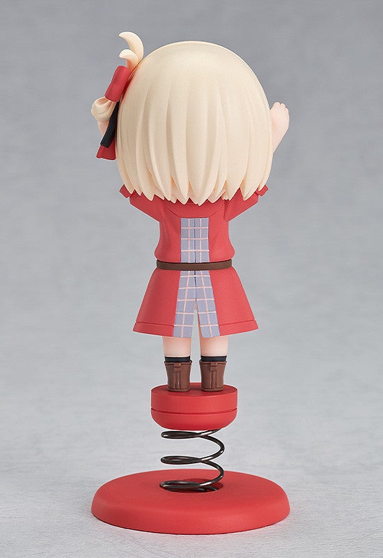 Back view of anime girl figure with blonde hair and red eyes wearing a red coat white shorts and brown boots on a red spring base