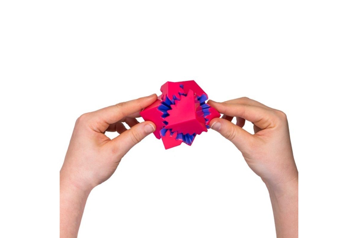 Hands manipulating a complex, pink and blue spiked modular puzzle cube