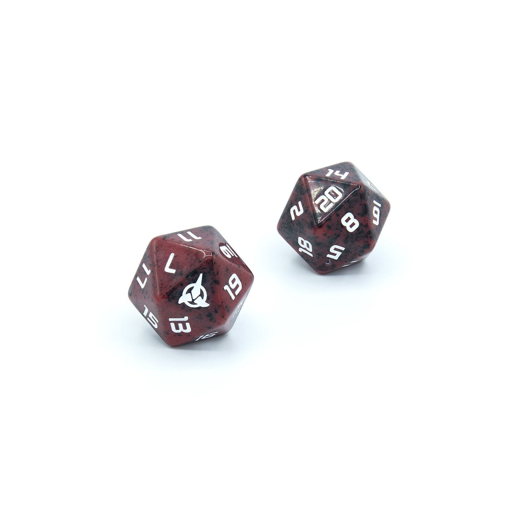 Two red speckled 20-sided dice with white numbers. One die features a white Starfleet insignia
