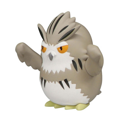 A cute chunky owl-like character figure with brown and white markings and big orange eyes
