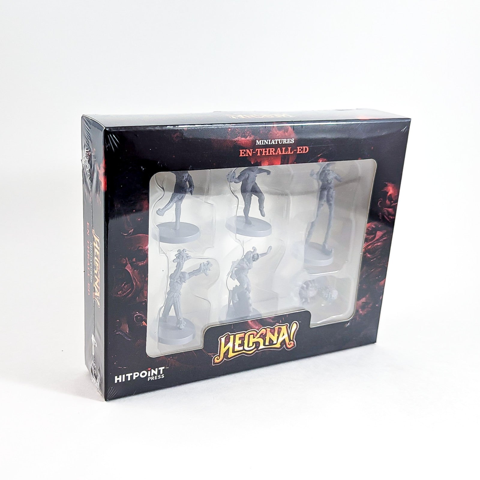 Black, shrink-wrapped box of "HECKNA! EN-THRALL-ED" miniatures with a window showing 6 unpainted grey figures.