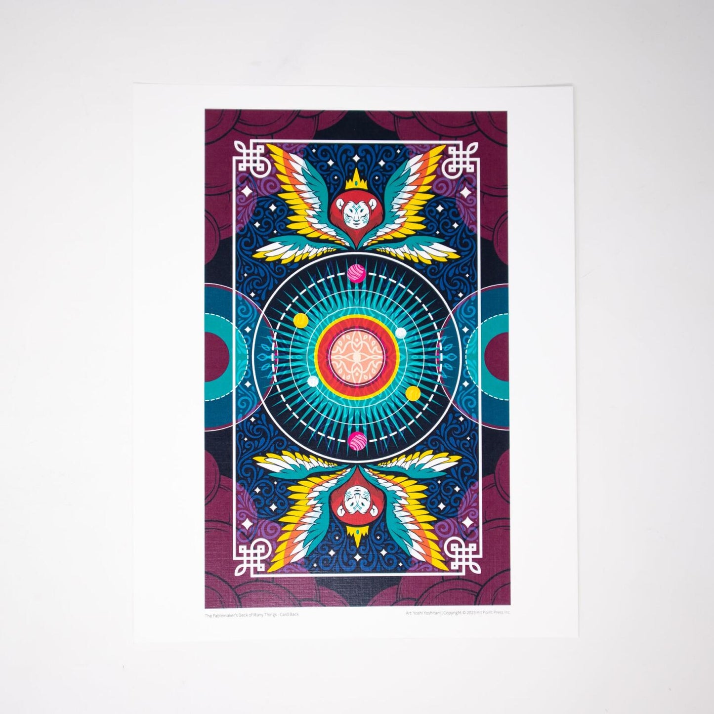 Vibrant, symmetrical Fablemaker's Deck of Many Things card back, with winged monkey heads & celestial center