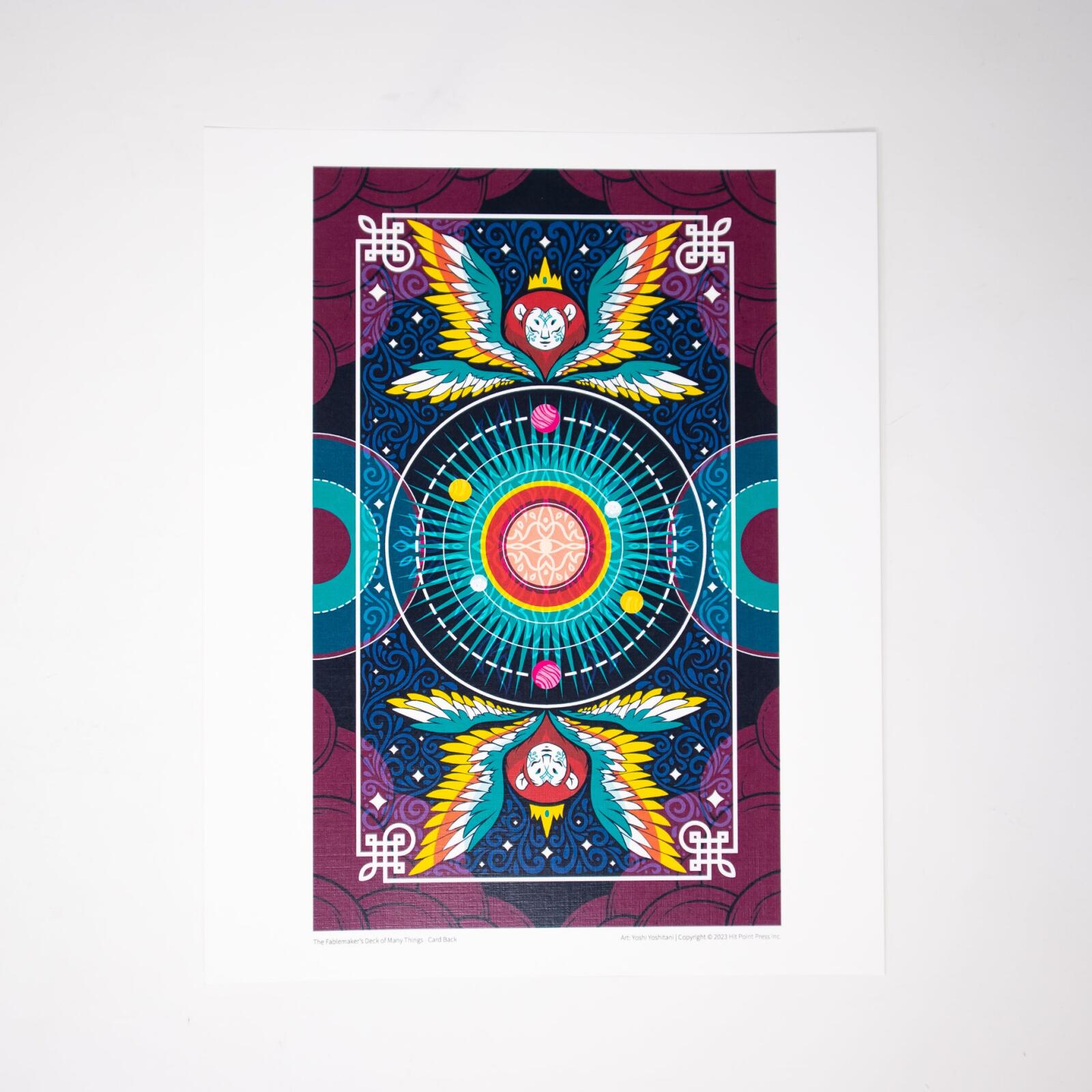 Vibrant, symmetrical Fablemaker's Deck of Many Things card back, with winged monkey heads & celestial center