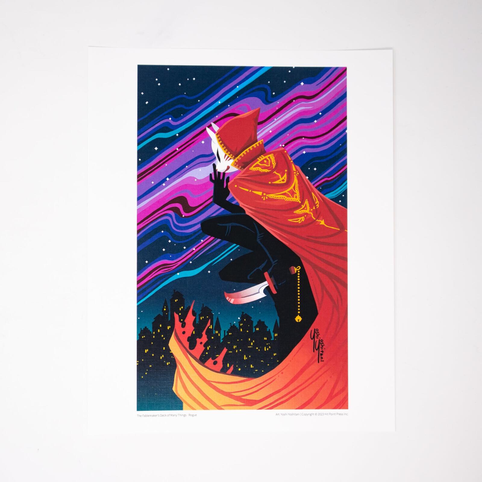 A masked rogue in a red cloak with a knife crouches over a city under a vibrant, starry sky